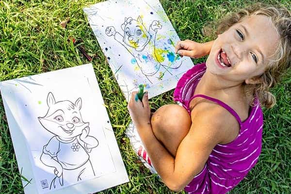 little girl creating bubble art in the grass