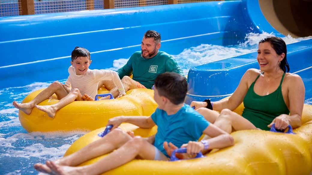 family enjoying riding tubes in a waterpark