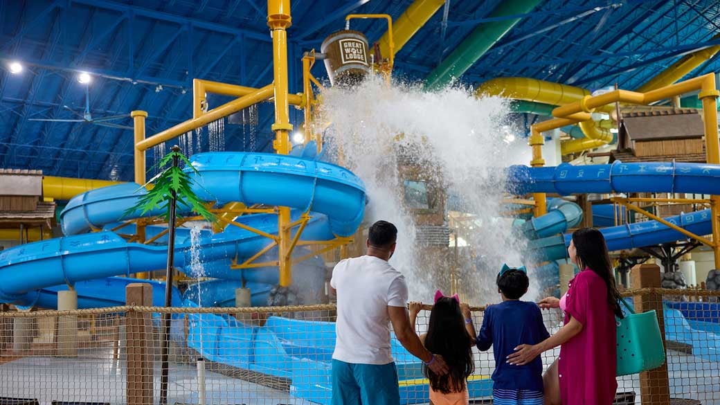 family enjoying water falling from a bucket in a waterpark