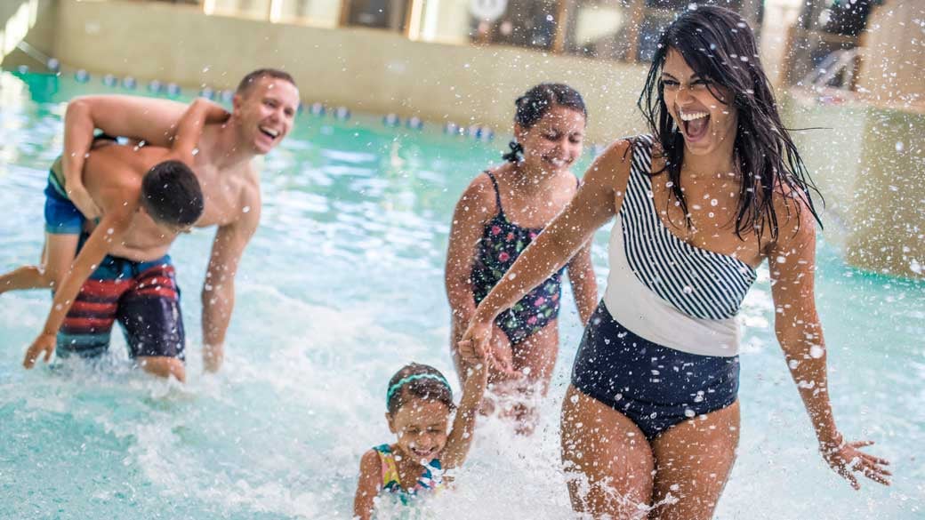 family enjoying splashing in the pool in a waterpark