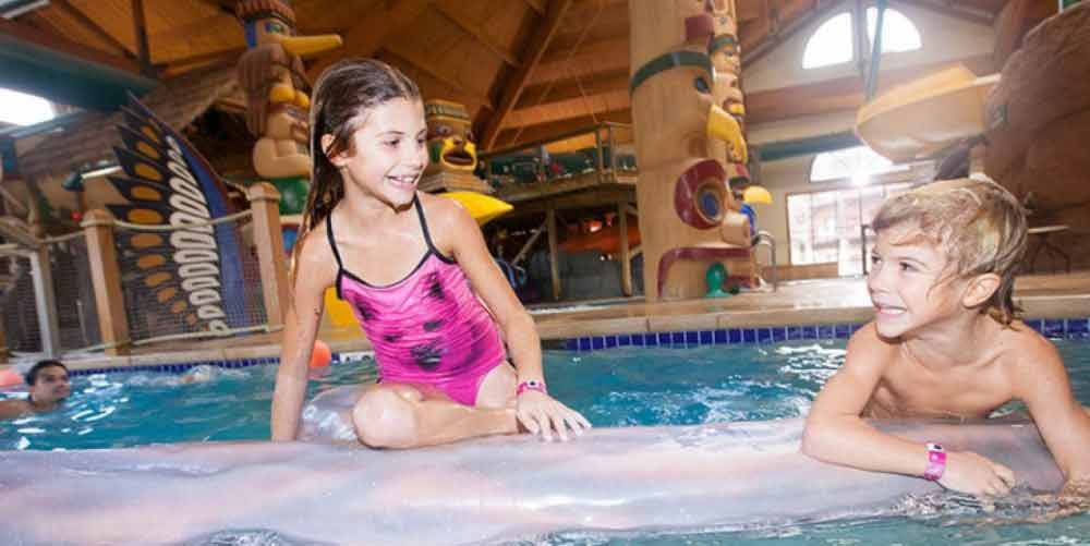 Child balances on log at Great Wolf Lodge indoor water park and resort.