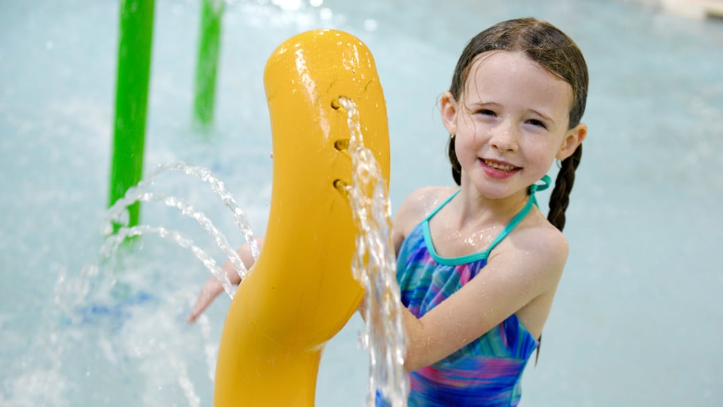 Kids play behind the outdoor water features 