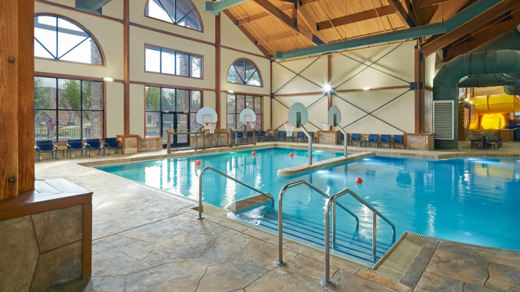 family playing basketball in indoor pool 