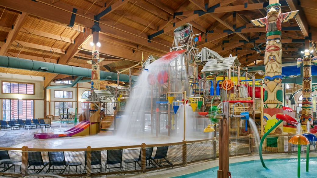 A wide shot of the  water treehouse as water splashes down from a bucket above the jungle gym