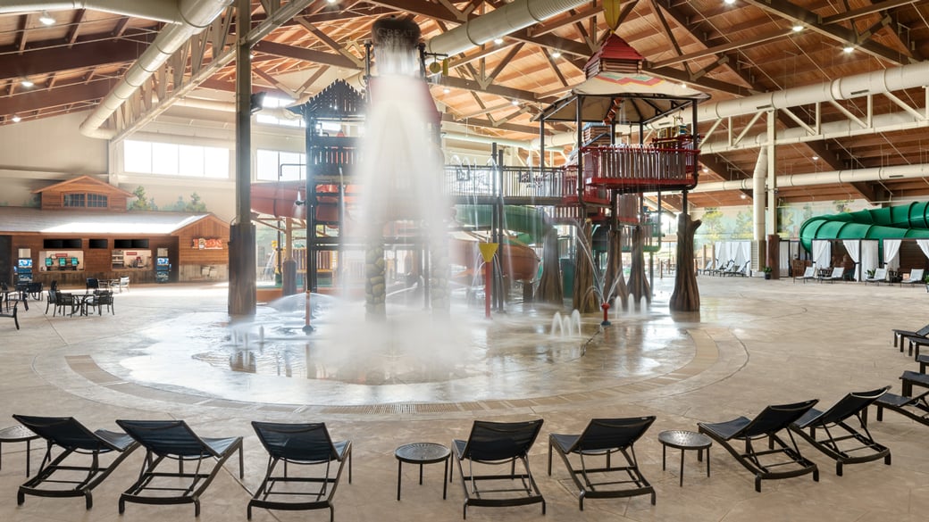 A wide shot of the  water treehouse as water splashes down from a bucket above the jungle gym