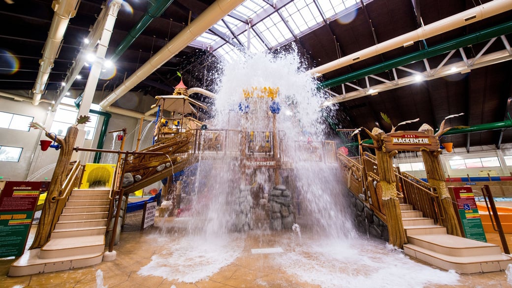 A wide shot of the  water treehouse as water splashes down from a bucket above the jungle gym