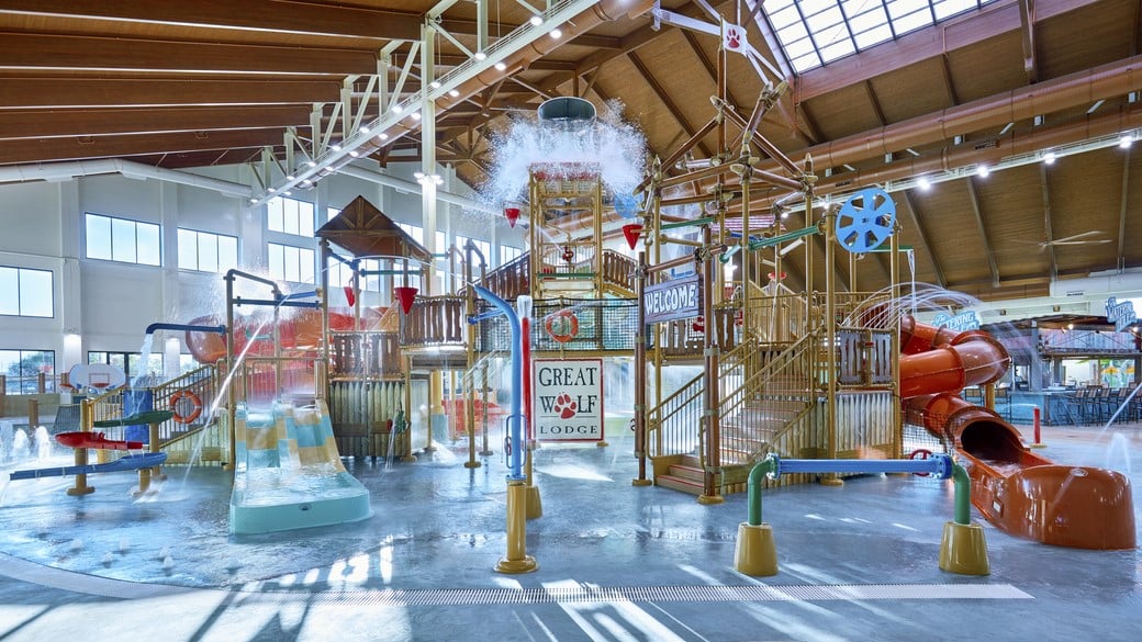 Water bucket splashes water over the top of the stairs and slides of indoor water park