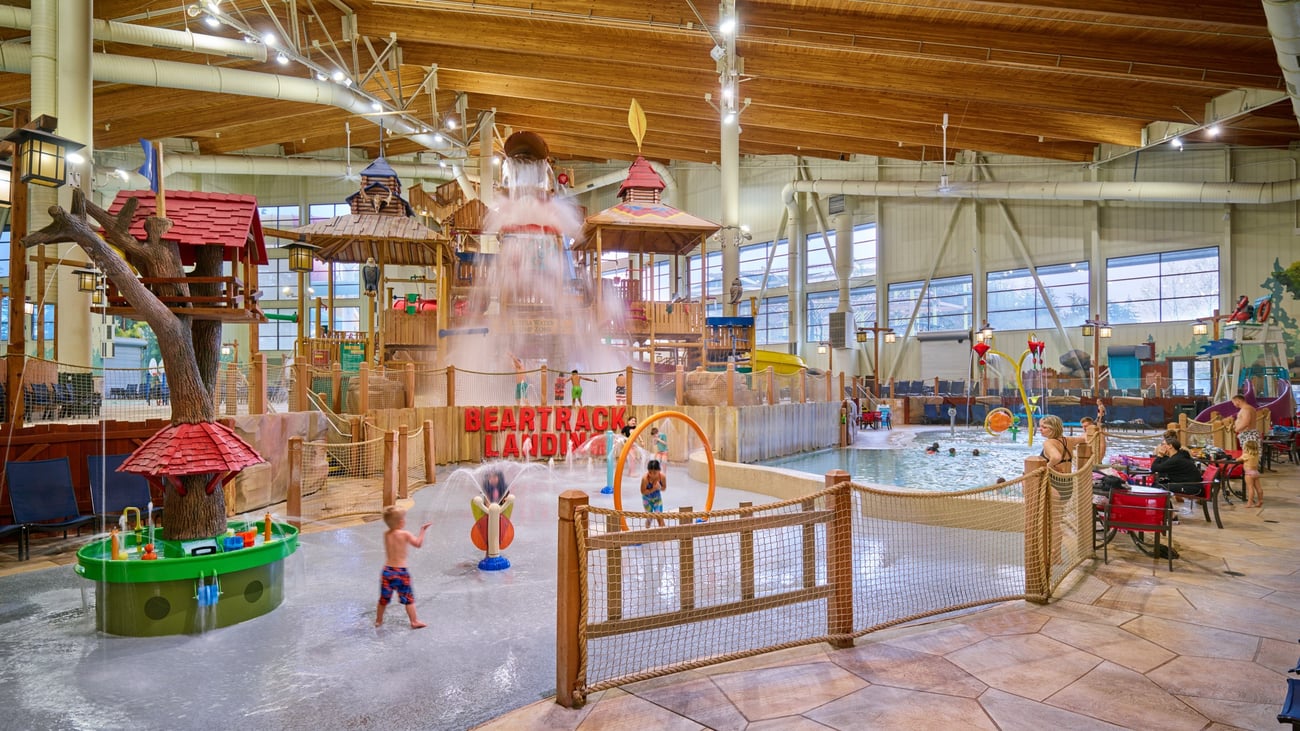 A wide shot of the  water treehouse as water splashes down from a bucket above the jungle gym