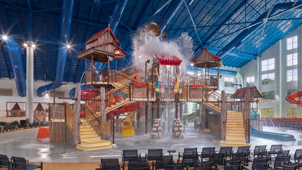 A wide shot of the  water treehouse as water splashes down from a bucket above the jungle gym