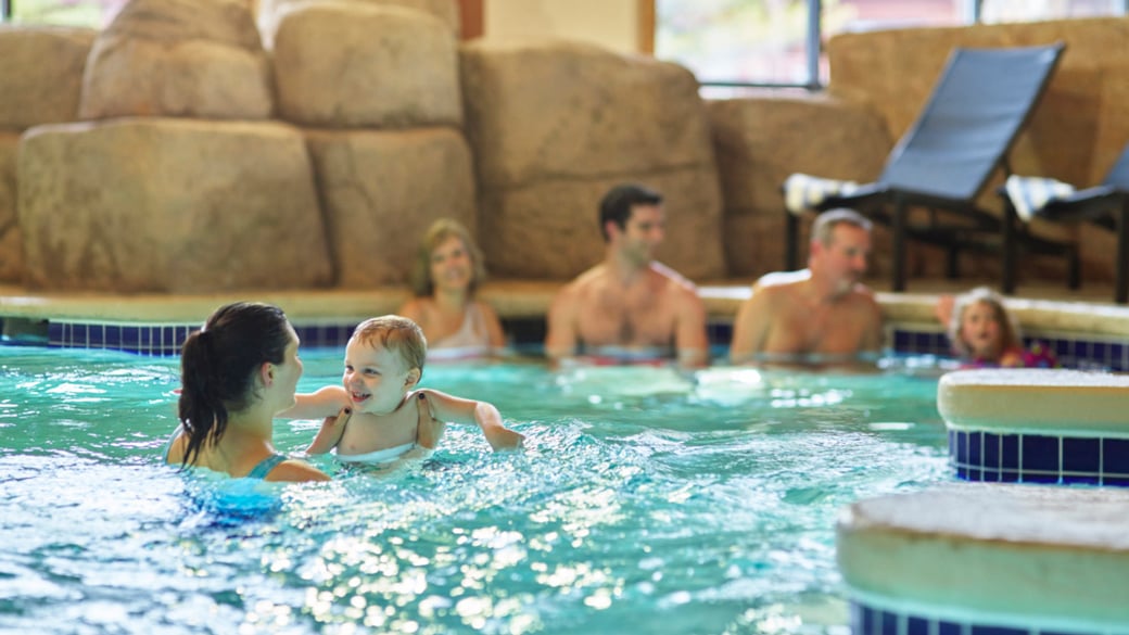 Mother holding baby in a pool 