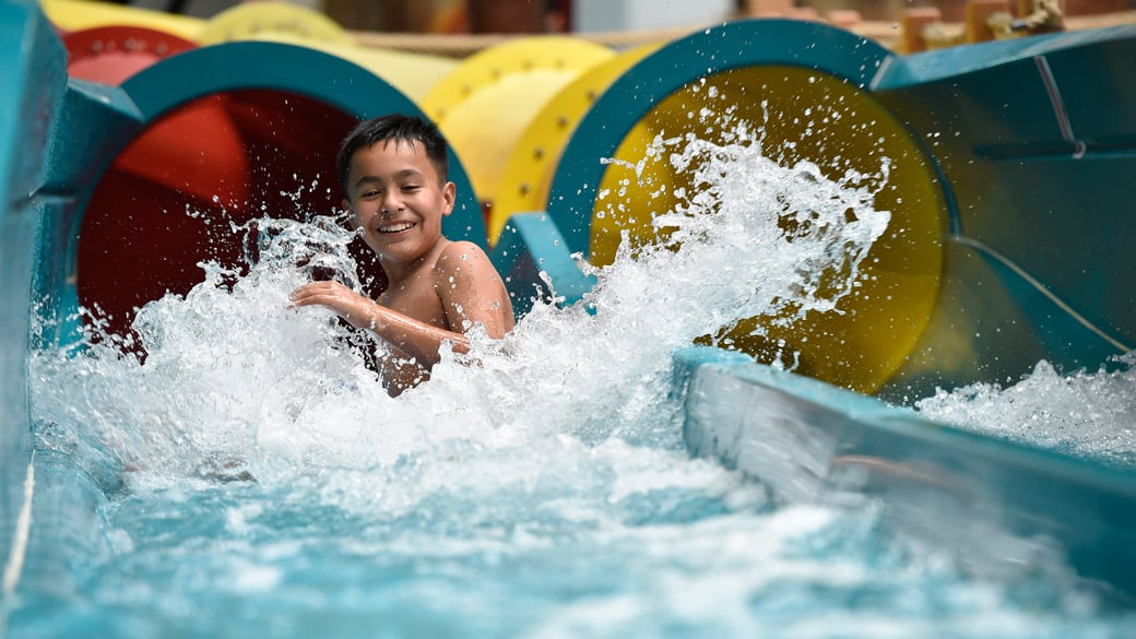 kid rides down waterslide