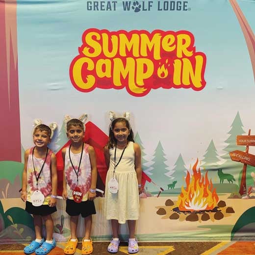 three siblings in front of a summer camp in mural