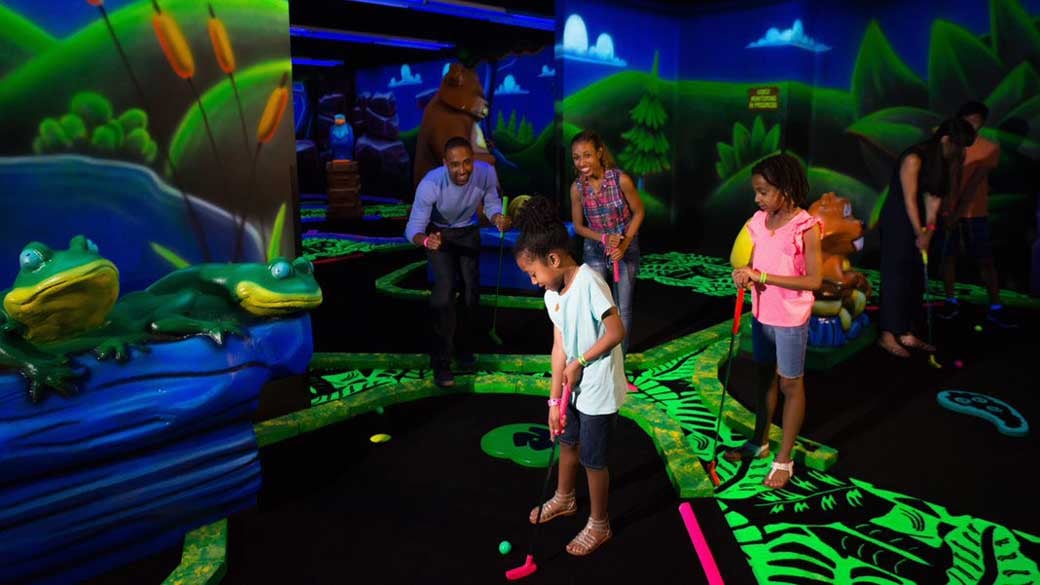 Family playing mini golf