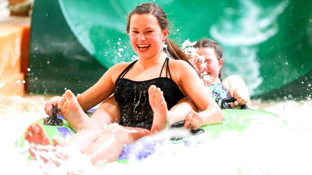 two girls sliding down on a water slide