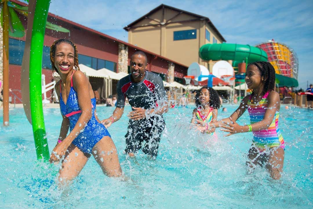 family playing in outdoor pool