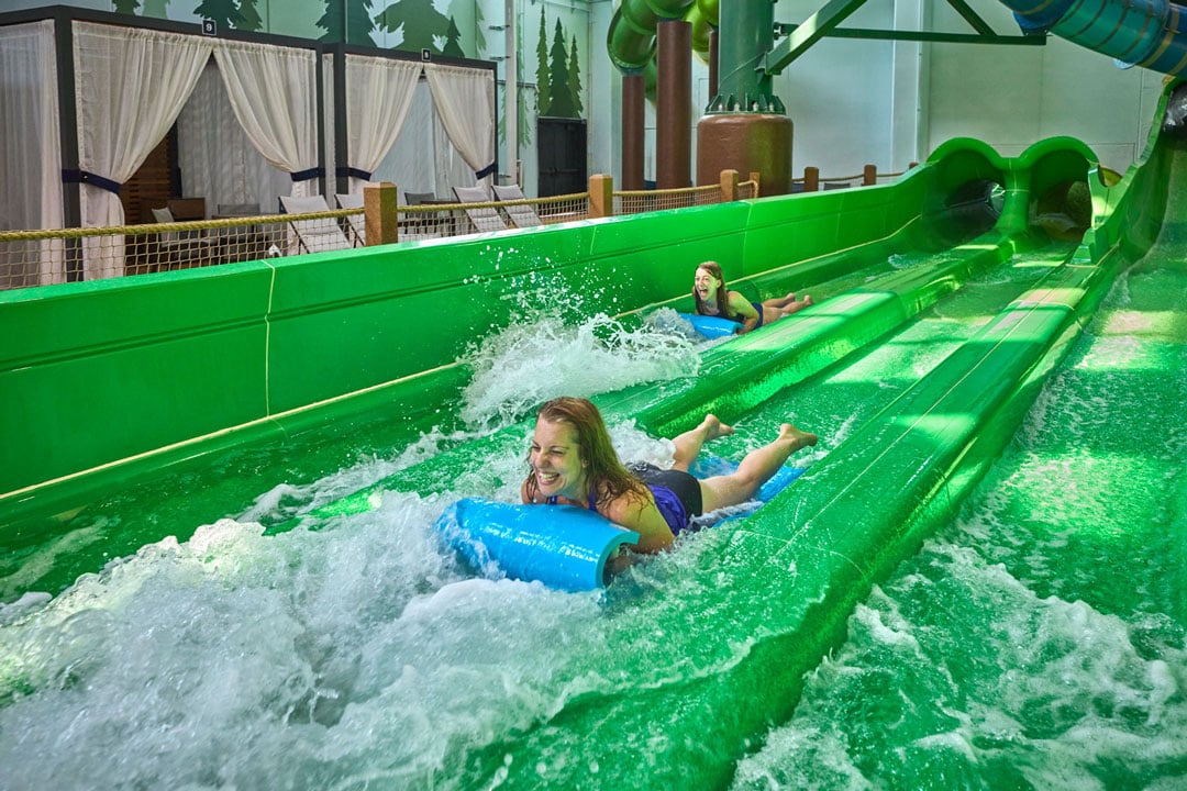 Mother and daughter sliding down a water slide in a blue slider 