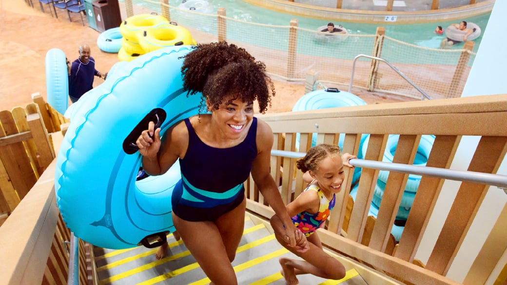 Mom and daughter getting ready to go down on a water slide 