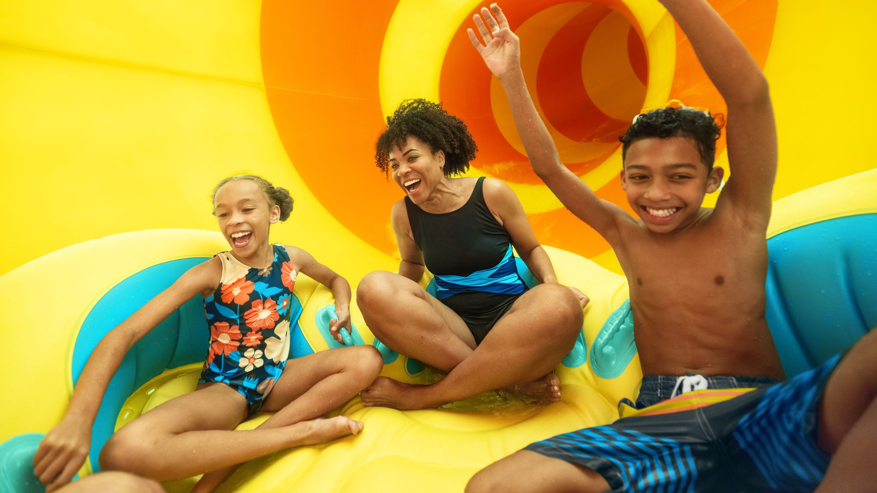 family enjoying sliding down a tube on a waterslide