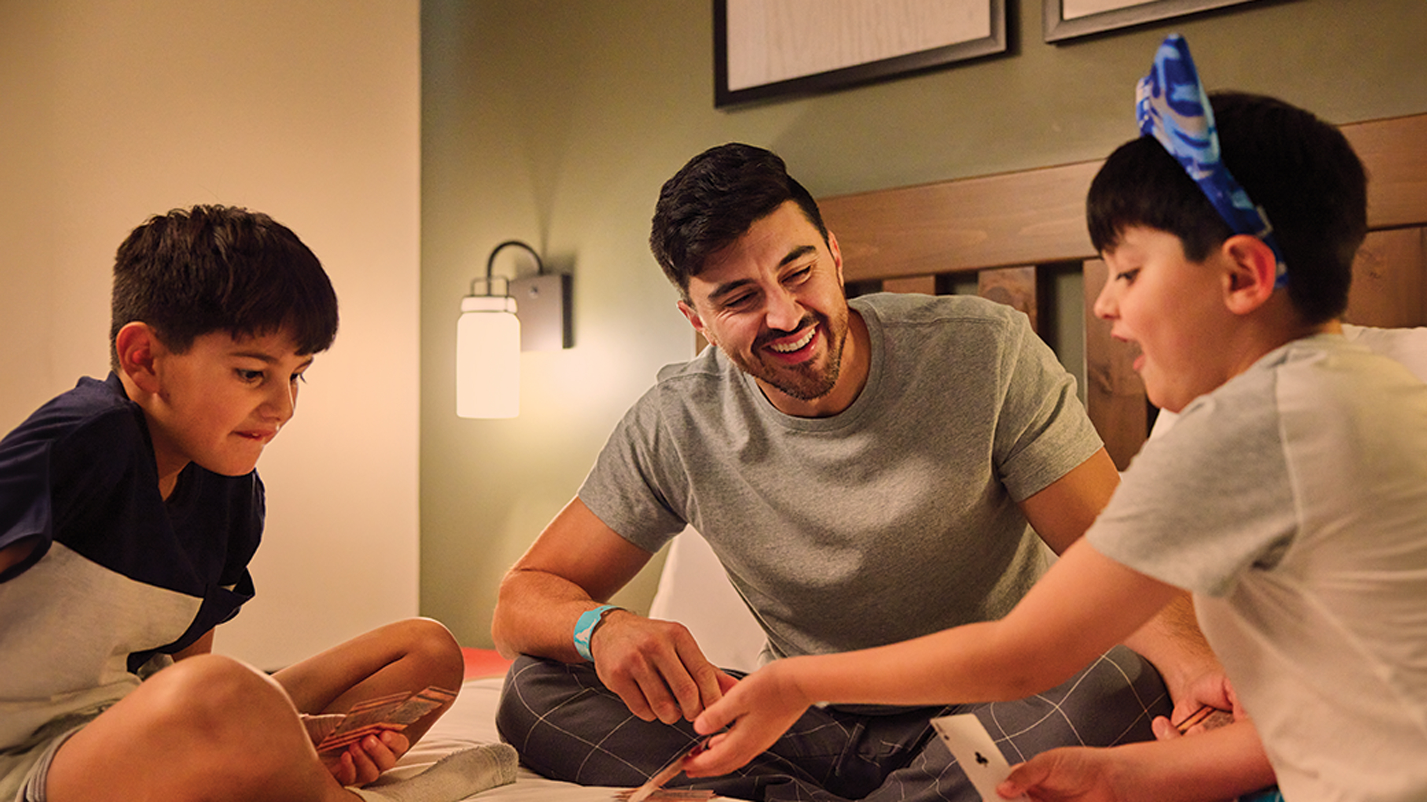 Father and sons playing cards in Great Wolf Lodge Suite