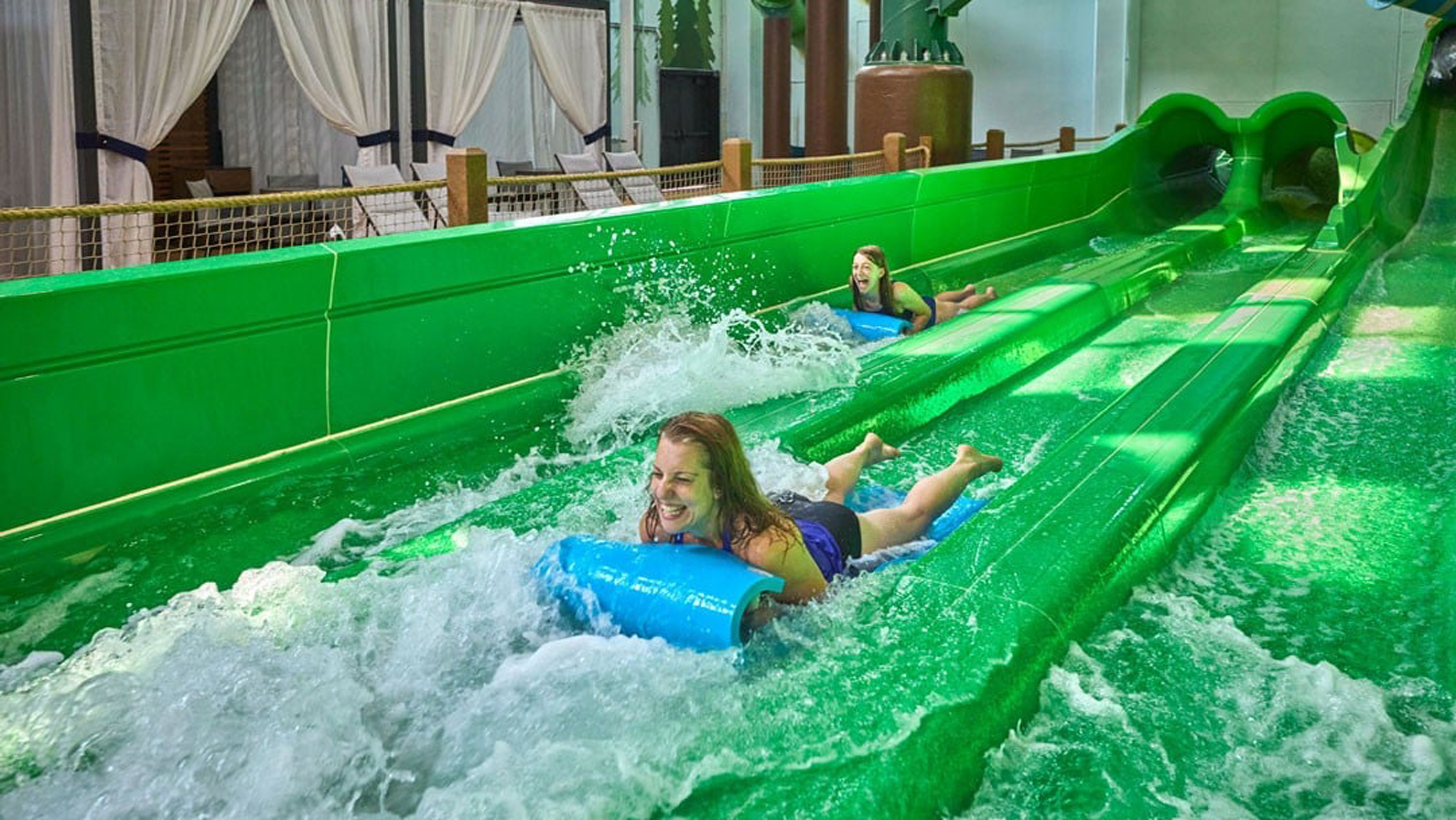 Mother and daughter slide down on a water slider