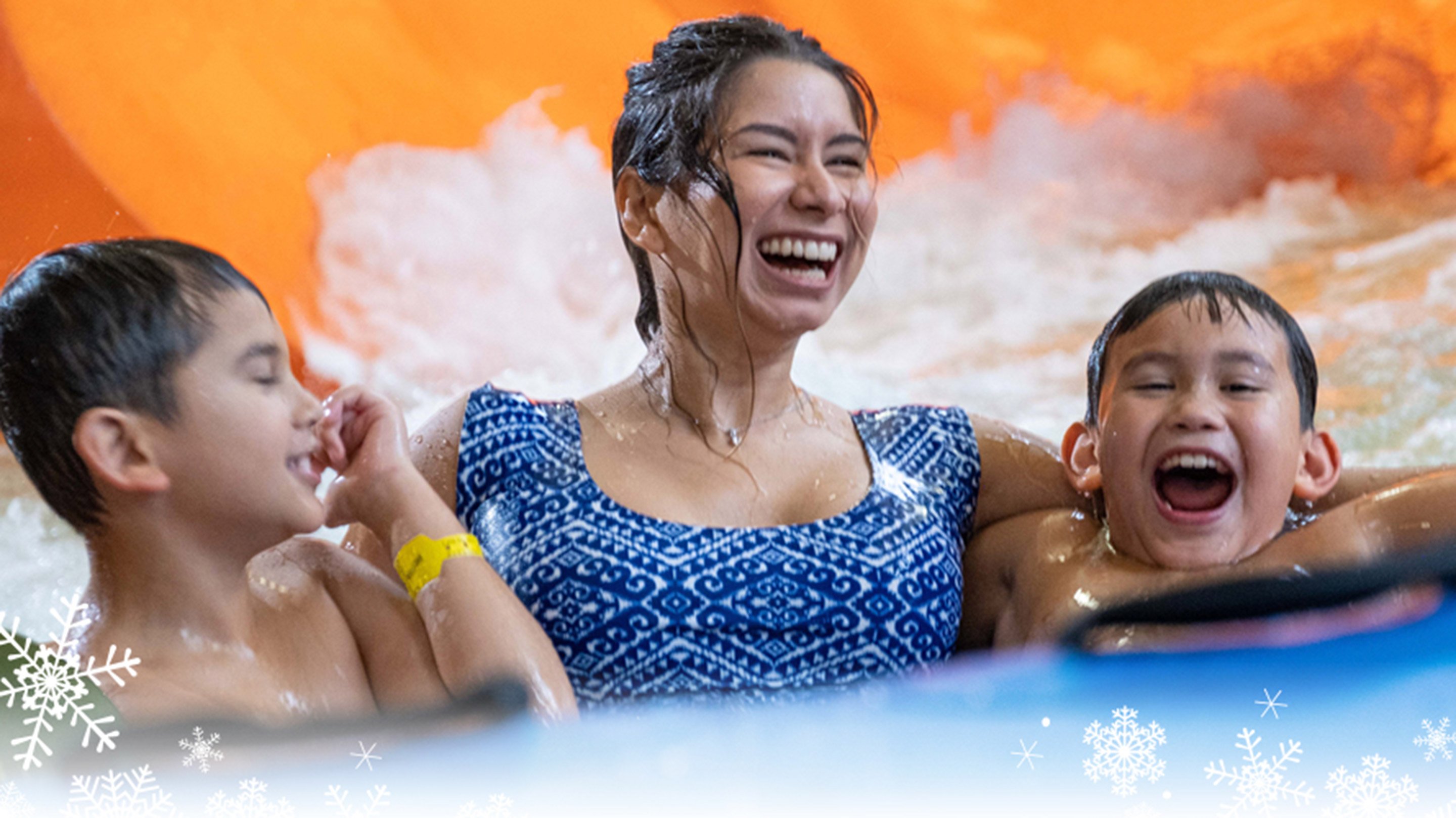 Mother and sons enjoying fun indoor water slides