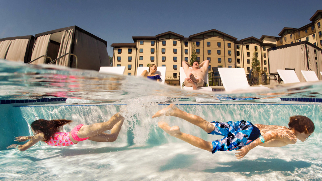 Brother and sister swimming in an outdoor pool at Great Wolf Lodge 