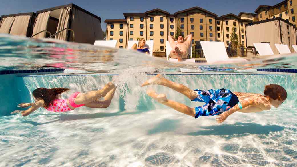 Brother and sister swimming in an outdoor pool at Great Wolf Lodge 