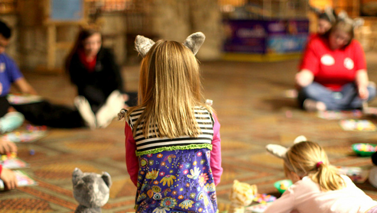 children in wolf ears sit in a circle 