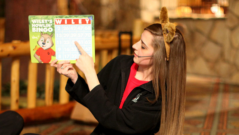 An employee in wolf ears reads from a story book