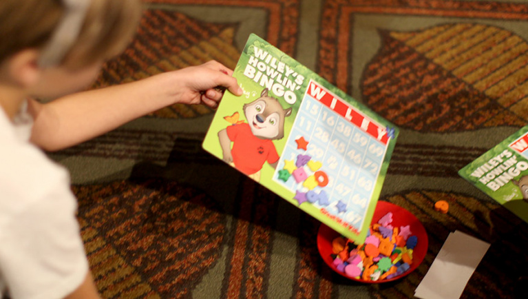 A young girl playing wileys howlin bingo at the pajama party at great wolf lodge