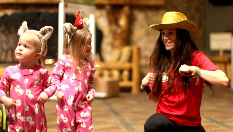 Great Wolf Lodge pack members lead two young girls in a dance