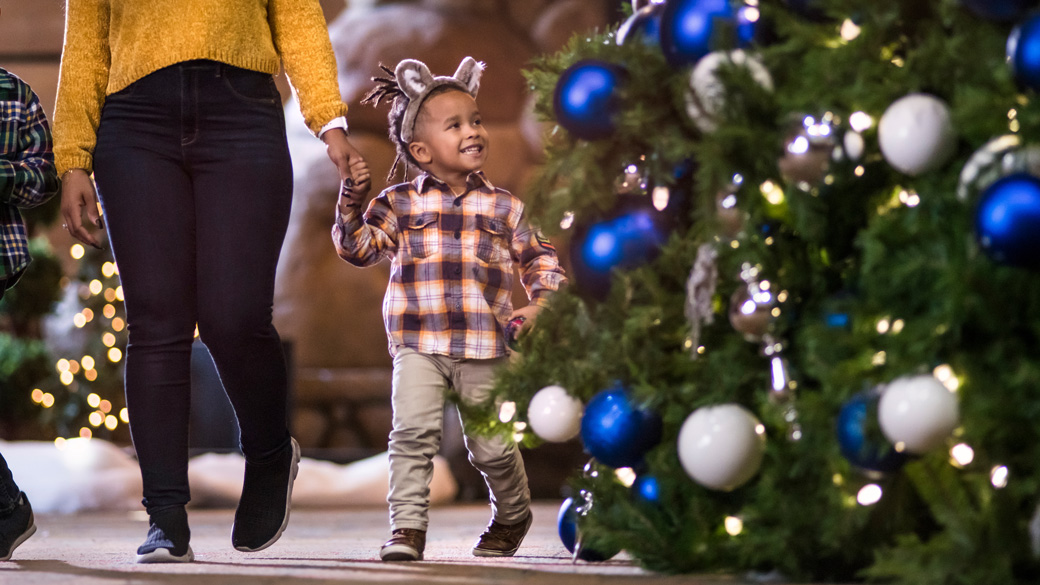 mom and son walking next to a Holiday tree