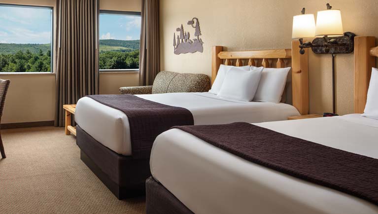 Bedroom with two queen beds in Grizzly Wolf Den Suite (Accessible Bathtub)