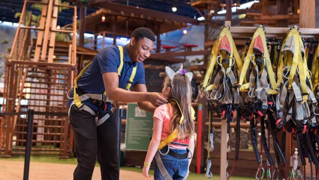 Pack member helping a girl putting her harness