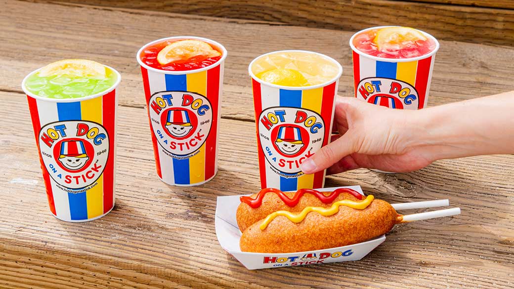 Hot dog on a stick with 4 different drinks