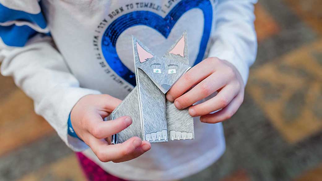 kid showing origami craft