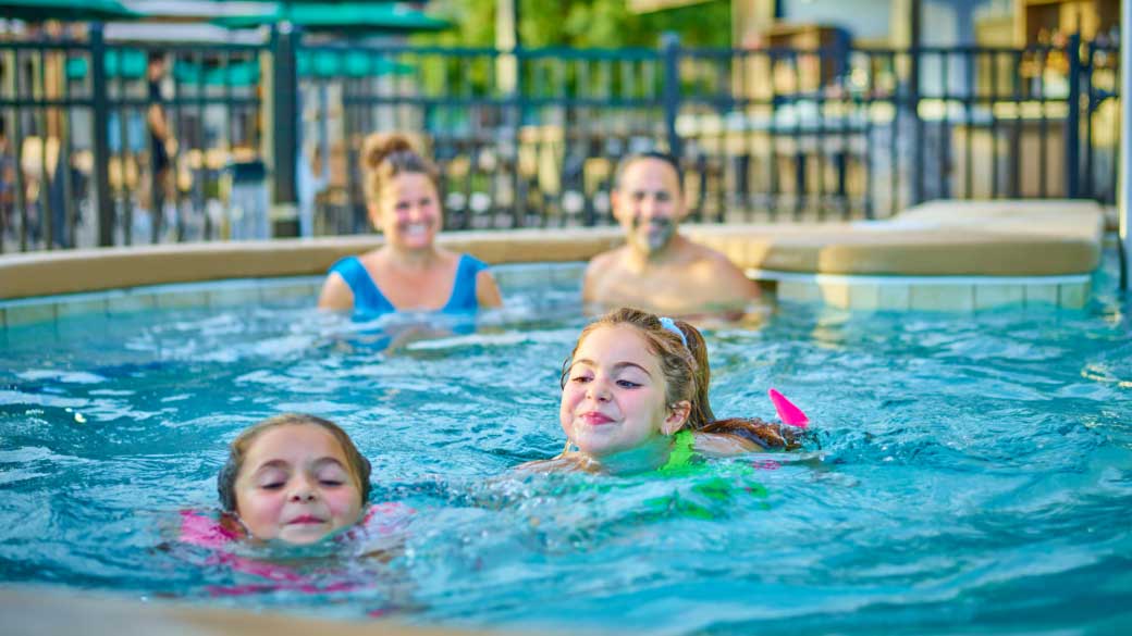 Family swimming in the pool having fun