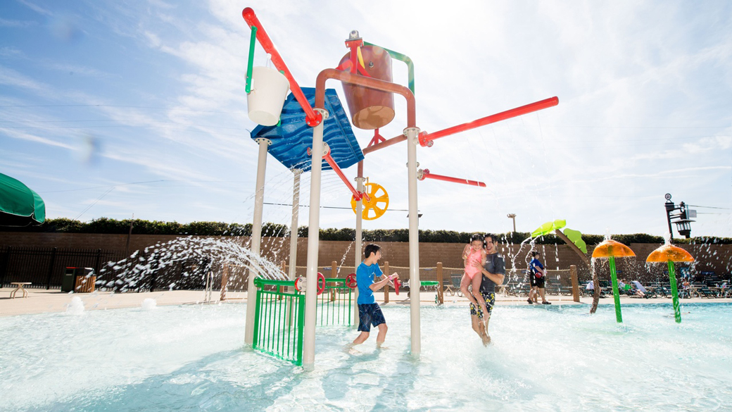 family playing in an outdoor pool