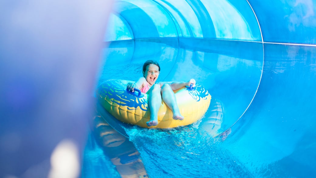 A girl slides down a water ride