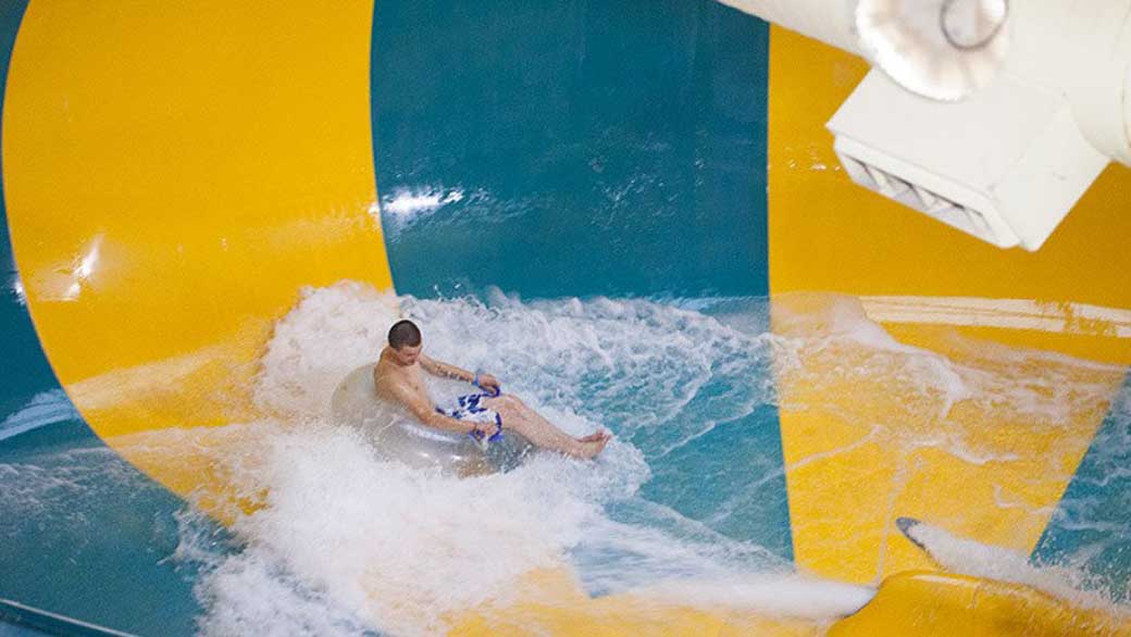 A guest enjoying the Coyote Cannon water slide at Great Wolf Lodge indoor water park and resort.