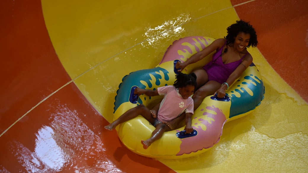 A guest enjoying the Coyote Cannon water slide at Great Wolf Lodge indoor water park and resort.