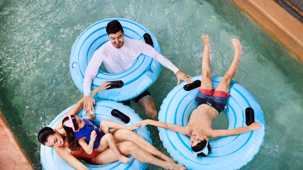 Family enjoying tube rides in the pool