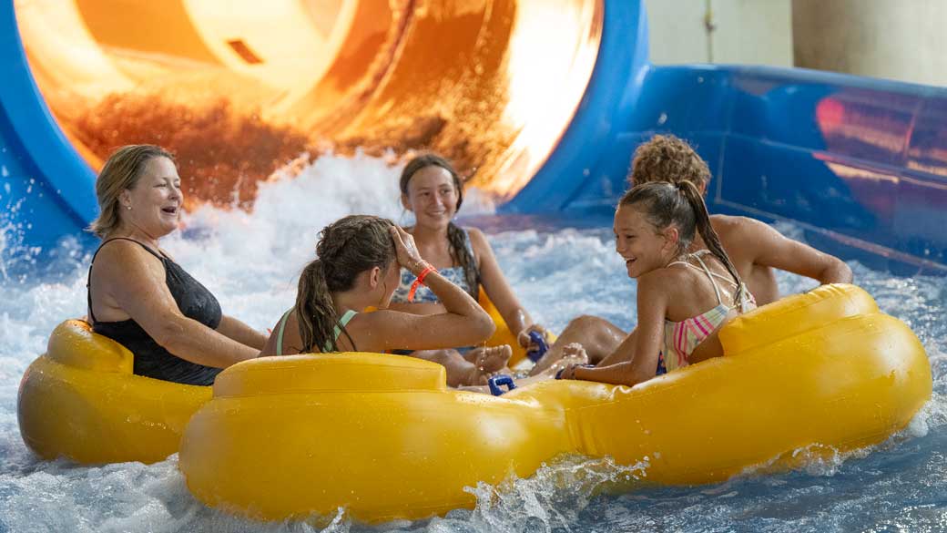 kids and mother riding a raft in waterpark 