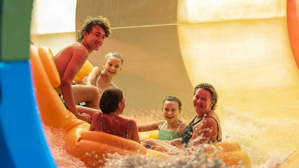 5 guests enjoying a raft ride sliding inside a tube