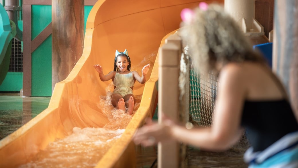 A boy slides down a water slide