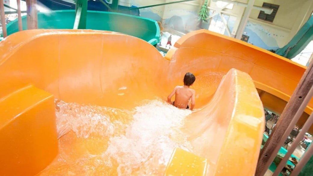 A boy slides down a water slide